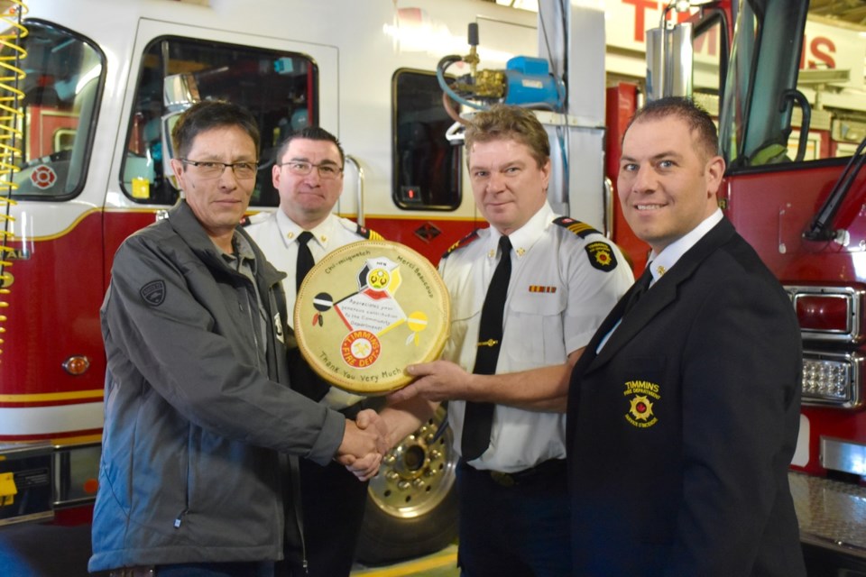 Mattagami First Nation Chief Chad Boissoneau and Fire Chief Wilbert Wesley give Timmins Fire Department Chief Training Officer Berny Stansa and Fire Chief Normand Beauchamp a handmade drum to express thanks for donating equipment to the community near Gogama. Maija Hoggett/Timmins Today