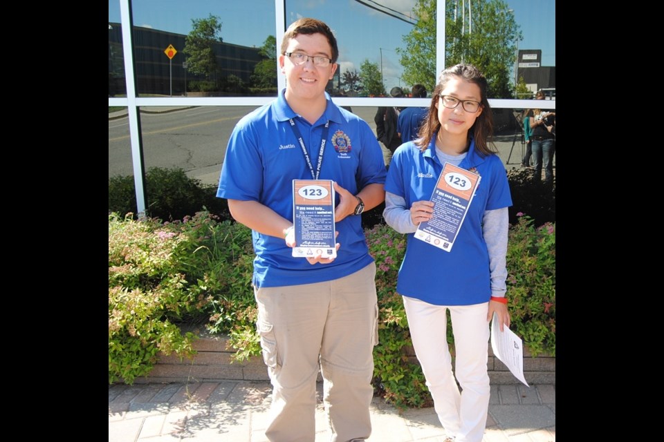 Youth in Policing Summer Students Justin Gadoury left) and Emily Lanthier (right) display the material they will leave with homeowners. Frank Giorno for TimminsToday