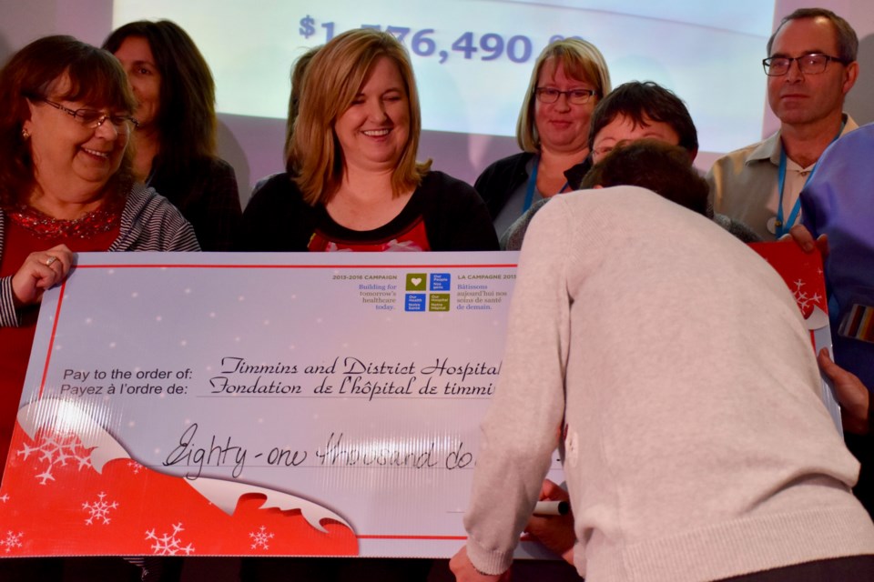 Timmins and District Hospital Auxiliary treasurer Bev Hannah signs a cheque for $81,000 for the TADH Foundation. Reps from the departments receiving equipment from the donation look on. Maija Hoggett/TimminsToday