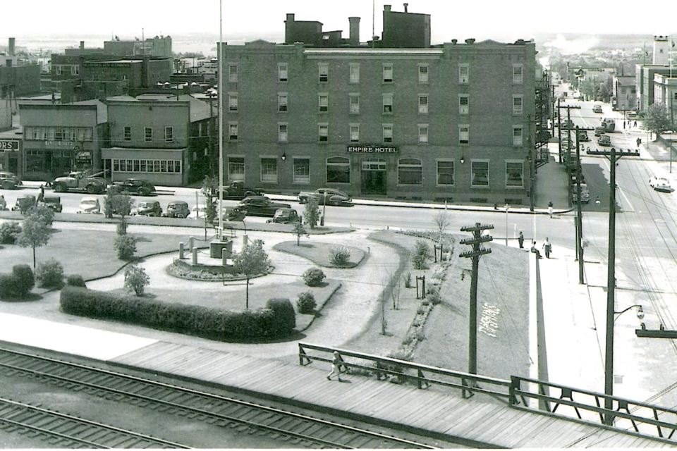 The Empire Hotel in Timmins in the late 1930s. The overpass and First World War memorial are in the foreground.