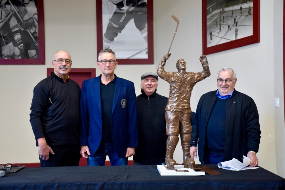 Wayne Bozzer, left, Paul Harrison, Mike Mulryan and Ed Pupich with the new Father Les Costello statue.