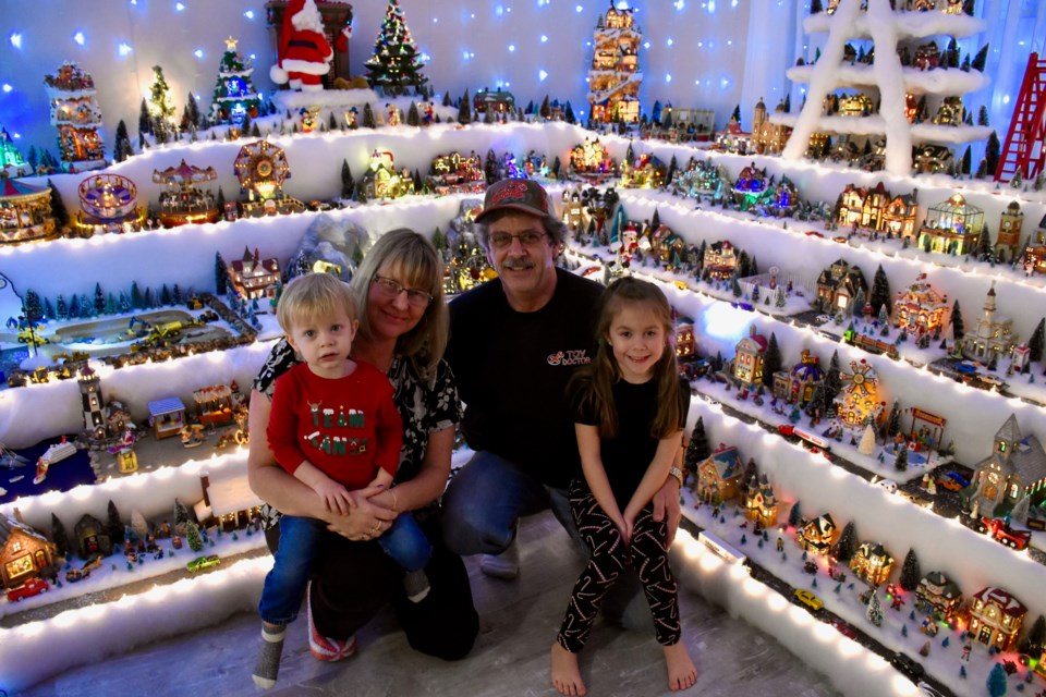 Diane and Andre Jasmin's Christmas village has snowballed into a tradition that takes up their entire living room. They're seen here with their grandchildren Camille Coutu, 5, and Simon Coutu, 2. 