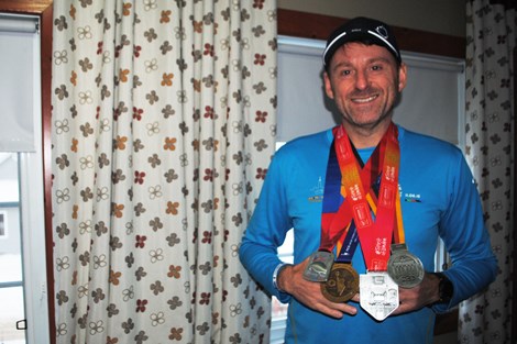 Marc Rodrigue, a local runner, wears four metals that he received after competing in various international marathons.