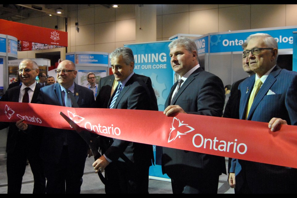 Bill Mauro, the Minister of Northern Development and Mines (third from left with the scissors) is about to cut the ribbon opening the Ontario mining pavilion at PDAC 2017. Frank Giorno for TimminsToday.