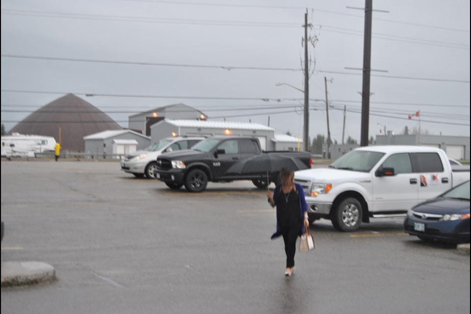 It pays to carry a little insurance these days with the every changing weather that fluctuates from sunshine to rain. Insurance agent Suzanne Gallant knows -- always have an umbrella close by  -- as walks in the rain while at Timmins Square. Frank Giorno for TimminsToday.