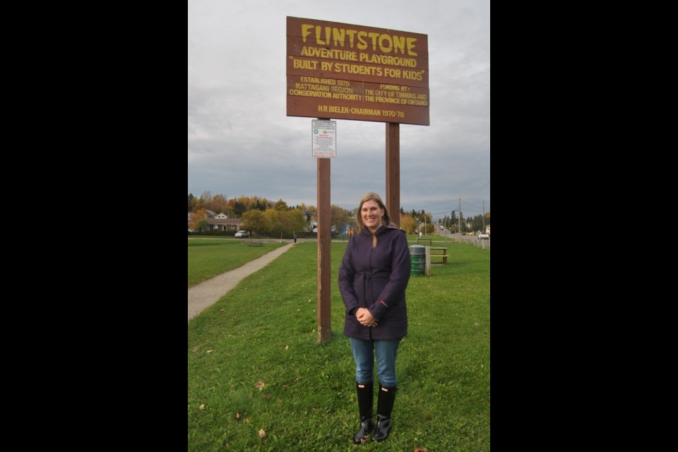 Crystal Spekking-Percival stands in front of the Flintstone Park sign in the Town Creek flood plain.Major flooding in the area in 1961 forced the removal of homes from the site. Flintstone Park was opened in 1975 on the site of the former Rea Conservation Area. The park once boasted a wooden Flintstone car. Photo:Frank Giorno, Timminstoday.com
