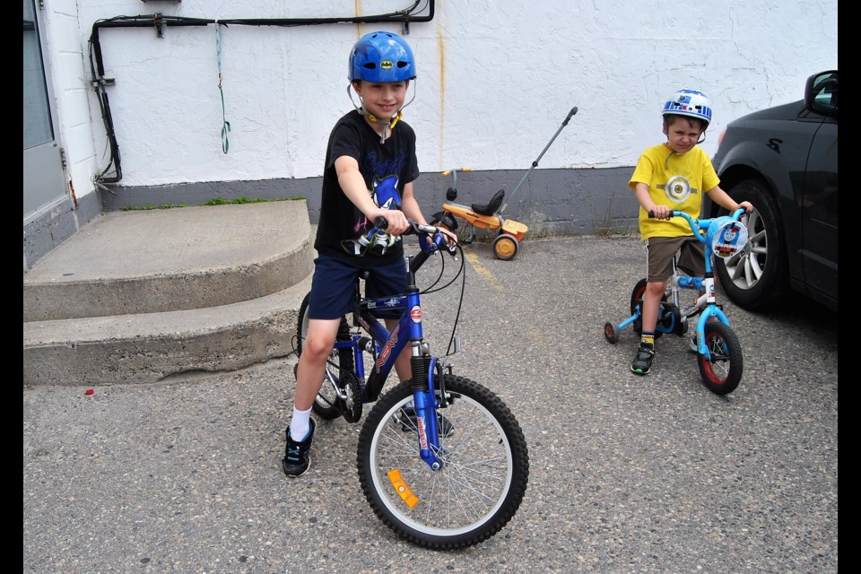 Jeffrey and Ethan Denis demonstrate the importance of wearing bike helmets when bike riding. The two brothers participated in Timmins Police's Helmets On campaign at Laser Tag yesterday. Frank Giorno for TimminsToday.