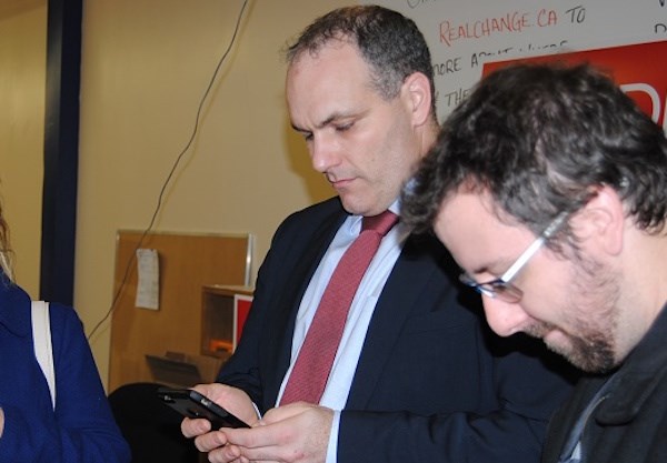 Todd Lever (left) during 2015 federal election checking results via smartphone. Frank Giorno for TimminsToday