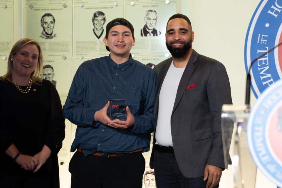 Kashechewan's Stephane Friday receives his Herb Carnegie Trailblazer Award from Rane Carnegie (Herb Carnegie's grandson) and Kim Saunders, Canadian Tire Corporation vice president ESG Strategy, Community Impact and Sport Partnerships.