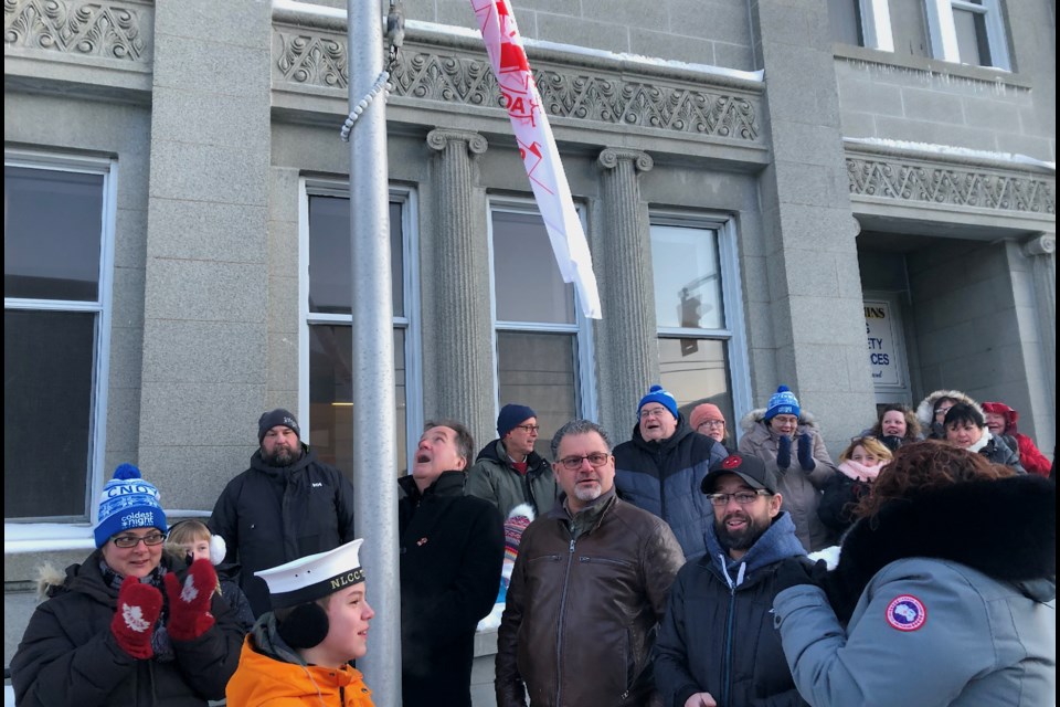 Timmins Mayor George Pirie looks up as he raises the Kin Canada flag outside of City Hall. The sunrise flag-raising ceremony marked the 100th anniversary of Kin Canada. The event was attended by members of the Timmins Kinsmen, Timmins Kinette and Porcupine Kinsmen Clubs and supporters. Wayne Snider for Timmins Today