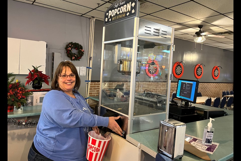 Natalie Berry, owner of Mid-Town Bowl in Timmins, shows off the new self-serve popcorn machine. The business has expanded offerings at its snack bar and added a modern arcade with prizes.