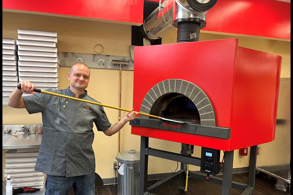 Sparks Pizza owner Tim Jamieson gets ready to make a pizza in the wood-fired oven. 