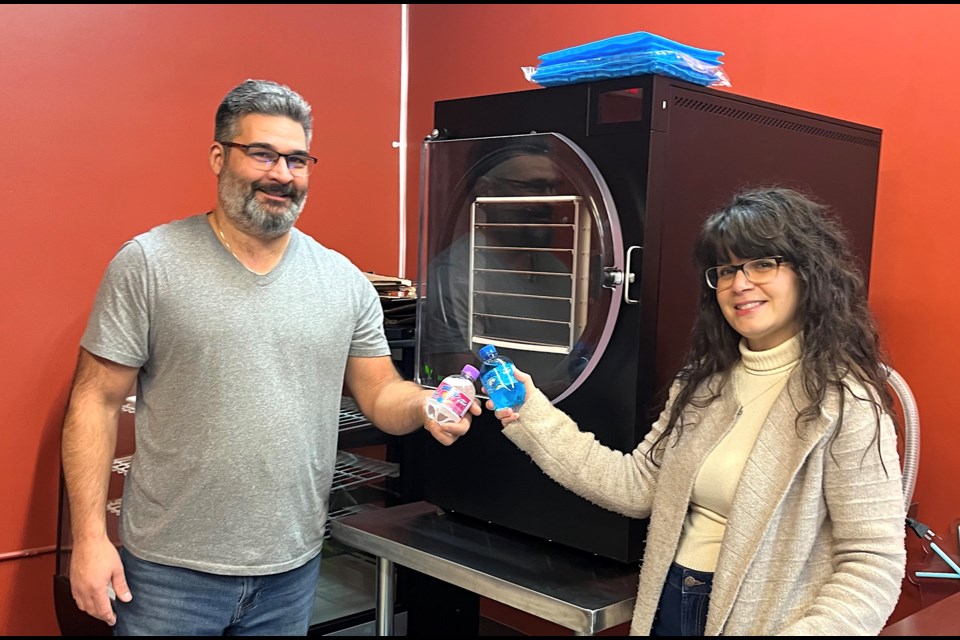 Sweet Freez owners Paul and Holly Doyon toast the future to their new store Sweet Freez. The store will not only sell retro and current candy, but producedfreeze-dried treats with three freeze driers, including the one behind them.
