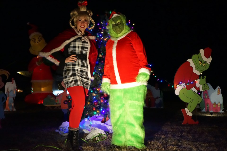 Cindy-Lou Who, better known as Allison Germain, and the infamous Grinch, played by Rhonda Ladouceur, pose in front of the elaborate and brightly-lit Whoville display in the Tri-Gen Construction yard.                                