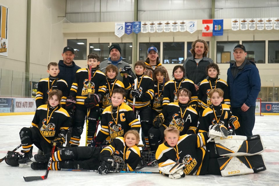 The Athabasca Hawks U11-1 team secured the silver medal on home ice after a hard-fought battle against the Bonnyville Pontiacs on Sunday, Jan. 21 afternoon, with a final score of 8-2. Posing for photo after the medal ceremony are, back row, L-R, coach Greg Weppler, coach Dan James, coach Stephane Landry, coach Brad Chaput. Third row, L-R, Ethan Chaput, Wyatt Loziak, Angelko Lugonja, Clive Boven, Bear St. Loius, Sawyer Willis, Eli Knisley. Second row, L-R, Carter Richards, Rayder James, Jack McGinnes, Brody Legace. Bottom row, L-R, Scott Weppler, Grayson Van Boxtel.                               
