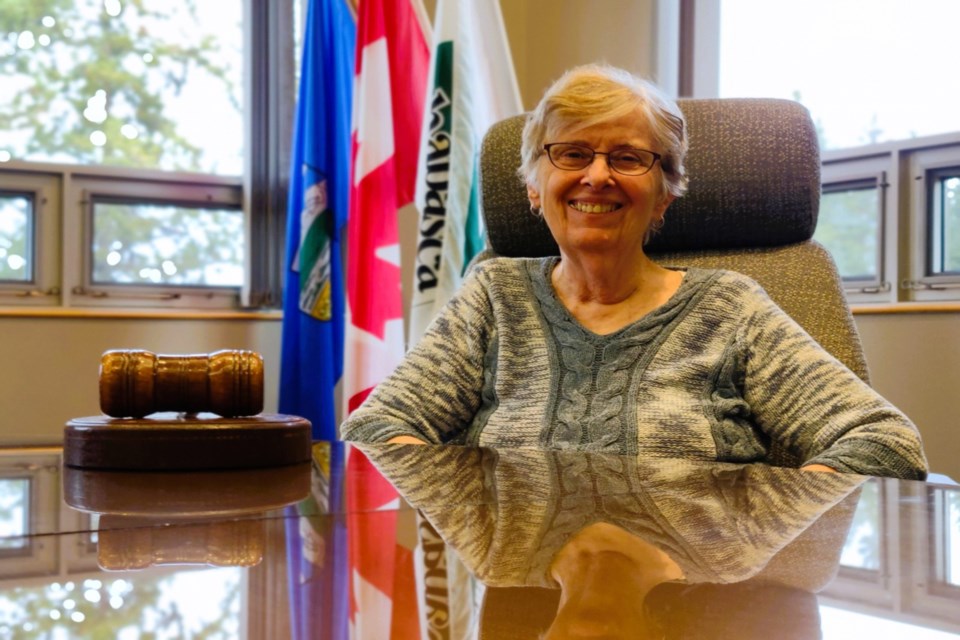 With her trademark grin, Colleen Powell posed from the mayor’s chair in Athabasca town council chambers Oct. 20, as the last days of her term, and political career ticked by.
