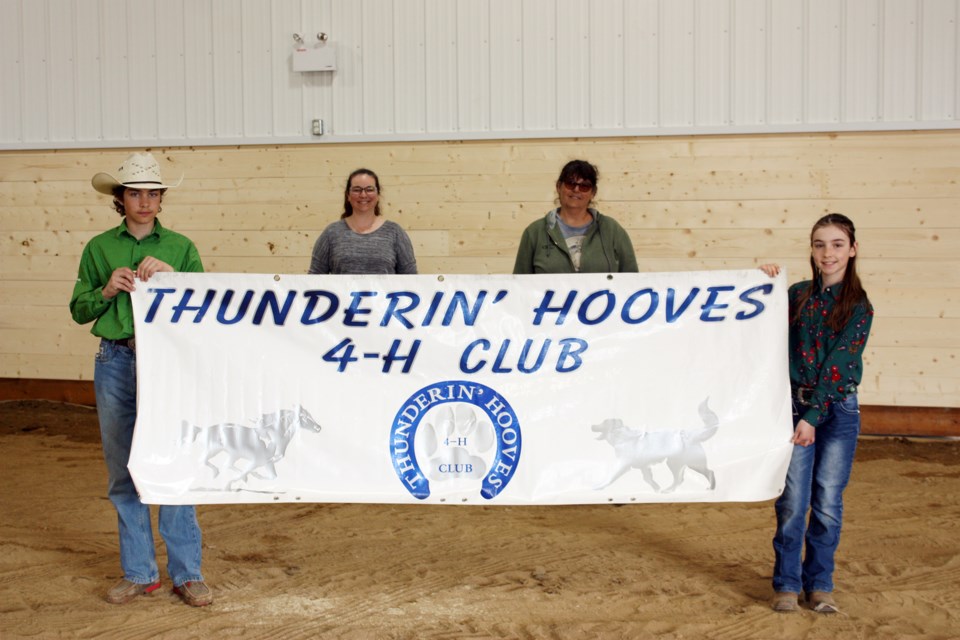 The Thunderin’ Hooves 4-H club will be one of the many user groups from around the Athabasca region that will make good use of the Ag Society’s new multi-use facility. The fundraising for the building is still underway with the $20,000 first place cash prize up for grabs with the purchase of a $20 ticket that can be found at businesses throughout town. Pictured: Ty and Isabelle Tremblay hold their club banner inside the new facility, with Ag Society director Katherine Tremblay and treasurer Dee Lambert keeping their distance behind the banner. 