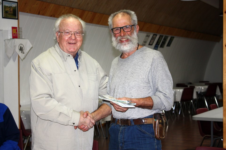Athabasca County Reeve Larry Armfelt presented Emile Brager with some lightweight mementoes in honour of his trip through the county on Feb. 9 at New Pine Creek Hall. 
Photos by Heather Stocking/AA