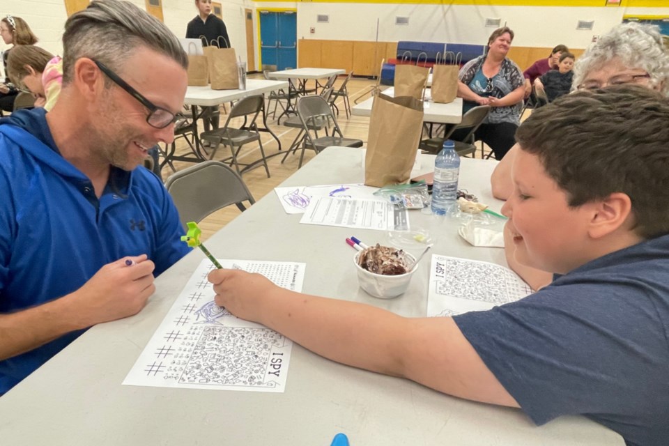 Athabasca County’s regional fire chief Sheldon Schoepp was one of 25 volunteer mentors for students in Grade 3 at Whispering Hills Primary School and Grade 4 at Landing Trail Intermediate School. Here, Grade 4 student Isaiah Bouchier, 10, whom Schoepp mentored, writes him a message upside down and backwards before they race through a word search.