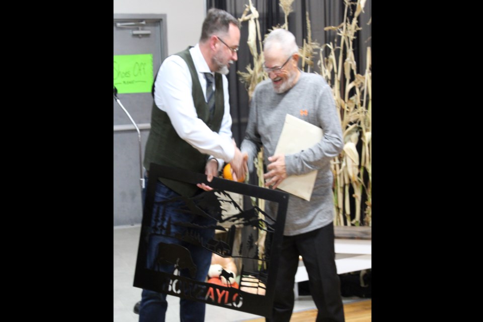 Athabasca County reeve Brian Hall presented Jim Bowzaylo with a custom-made metal sign in recognition of his 50 plus years of farming during an event at the Athabasca District Ag Society Harvest Supper and Dance Nov. 5.