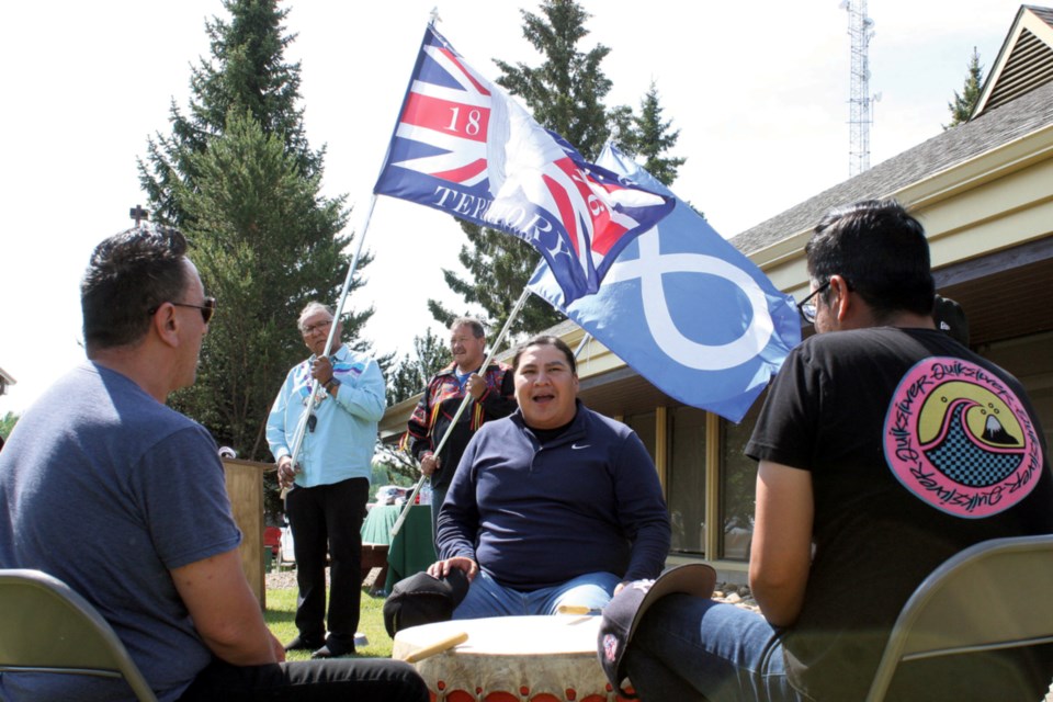 Aspen View School Division resident elder Phillip Campiou holds the Treaty 6 flag proudly as he and Metis Nation of Alberta Region 1 President James Cardinal, holding the flag of the Metis nation, prepare to exit the official flag raising ceremony held at the school division’s offices in Athabasca June 16. Various elders, dignitaries, performers and school officials were invited to the event that continues Aspen View’s work toward truth and reconciliation with its Indigenous students and families. On the drum Stan Arcand (foreground, left) was joined by the Kicking Horse Singers from Alexander First Nation, consisting of Creedon Arcand, Donnelly Paul and James Minoose.