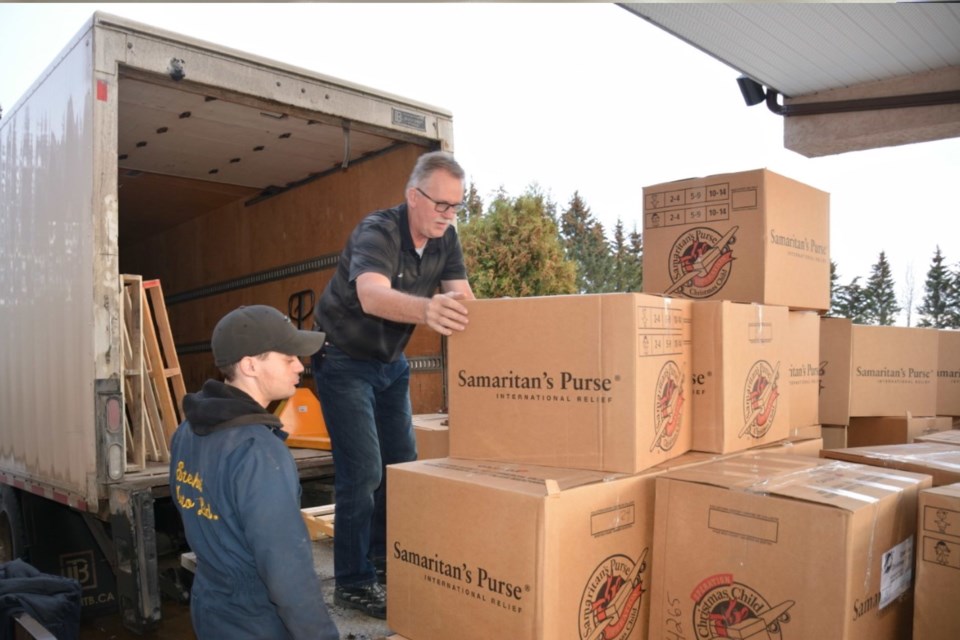 Levi Stephani and Jan Harink with the Neerlandia Co-op load up boxes containing items donated to needy children as part of Operation Christmas Child on Nov. 21. Volunteers worked throughout the Nov. 19-20 weekend at the Barrhead Alliance Church to get the 1,000-plus shoeboxes donated by Barrhead and area residents ready for shipping to other countries. 