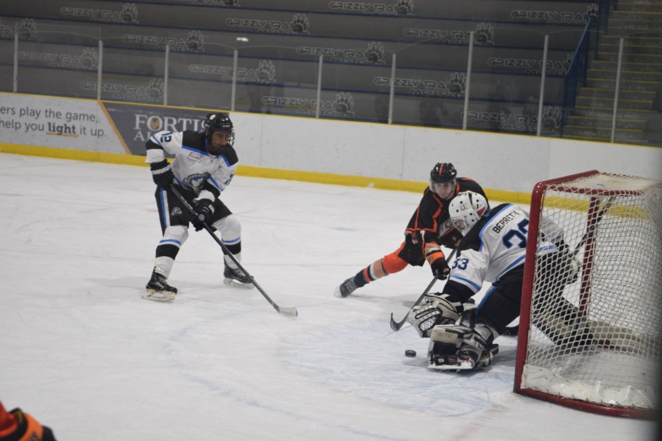 Barrhead Bombers goaltender Jace Berreth makes a save late in the third period, with forward Zion Fraser rushing in to clear the rebound.