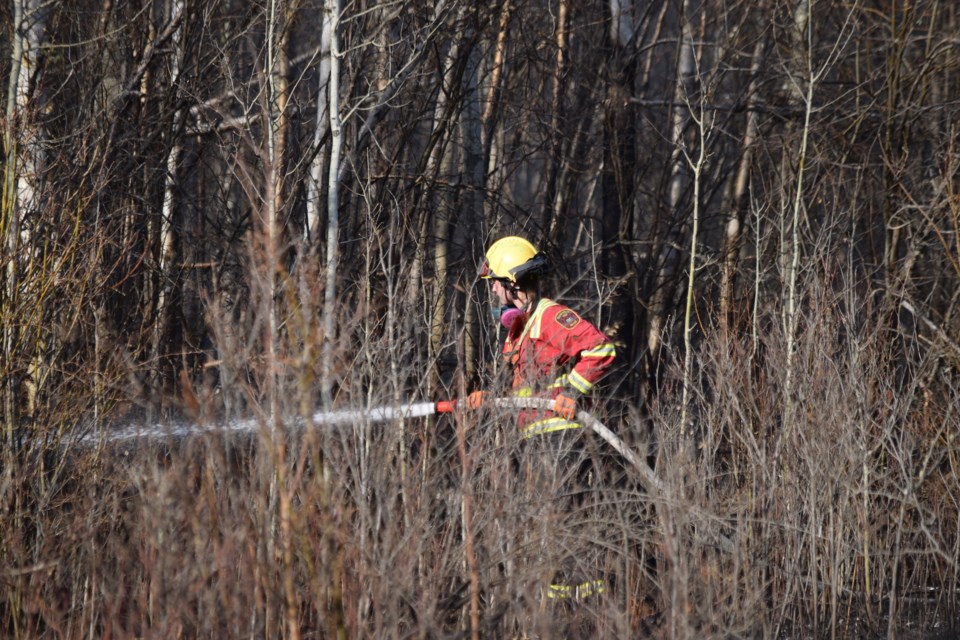 A BRFS firefighter sprays water on a hotspot left over from a wildfire that occurred near the Clear Lake Natural Area in the County of Barrhead on May 2.