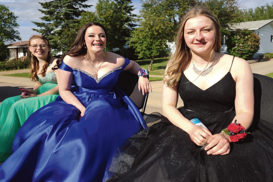 After the graduation ceremony June 18, Boyle School graduates including (L-R) Trinity Lachance, Daisy Irving and class valedictorian Kayly McNamara took their place on one of two flatbed trailers and made their way around the village in the school’s second annual reverse parade, where members of the community showed their support for the grads with colourful signs, decorations and shouts of pride and well-wishes for their futures. 