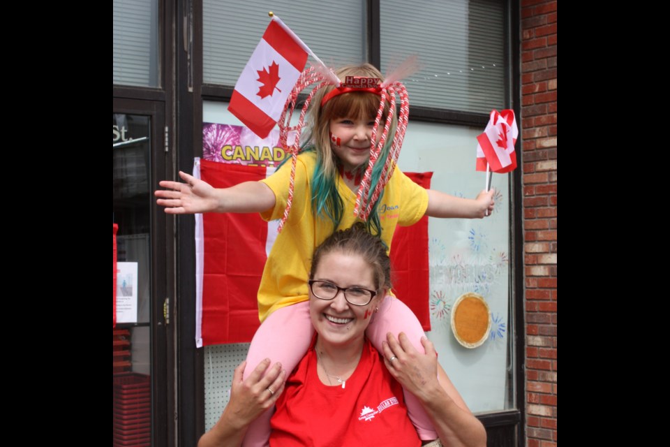 Things were a little different for Canada Day in Athabasca last Wednesday, as the usual events did take place, but with a coronavirus twist. With social distancing requirements in place, the usual parade became a reverse parade with local busi- nesses decorating their store fronts and waving from the sidewalk at the more than 200 vehicles that took part. Pictured, Carly Damon sits atop mom Renee’s shoulders in front of the Great Canadian Dollar Store in Athabasca July 1 as those participating in the reverse Canada Day parade drove by waving and honking to celebrate the day.
Chris Zwick/T&C