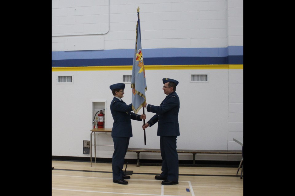 Former Barrhead 526 Air Cadet Squadron CO Capt. Susan Peters hands over the unit's flag to their new CO Lt. Kristian Olsen.