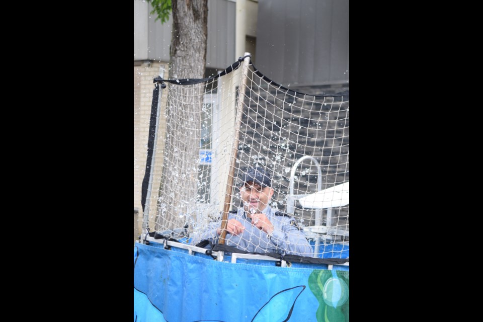 Barrhead RCMP Cpl. Filipe Vicente goes for a swim thanks to his daughter, Emma, who successfully hit the target of a dunk tank with a softball.