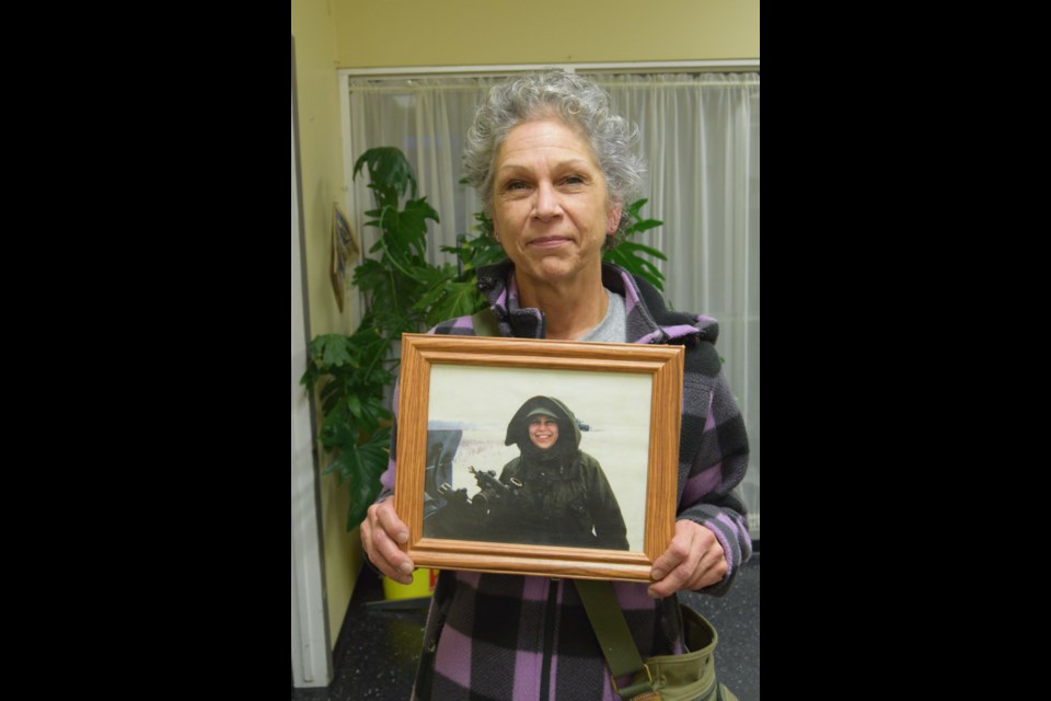 Dale Bernier, a Canadian Armed Forces veteran, holds up a picture of herself when she was stationed temporarily at Canadian Armed Forces Base Wainwright.