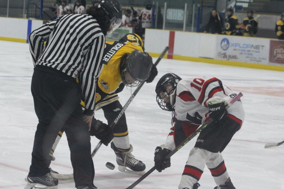 Drake Schlitter (in black) takes an offensive zone faceoff for Barrhead in the second period against Lloydminster's Graydon Moore.