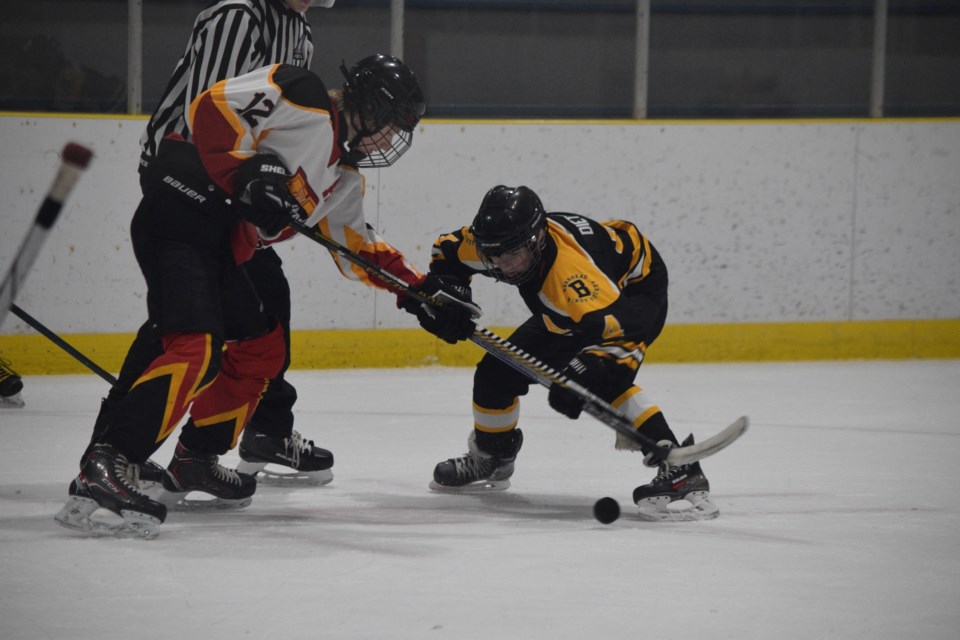 Barrhead Buck Greyson Dietrich in the face-off circle against Westlock U13 Warrior Derek Snyder.