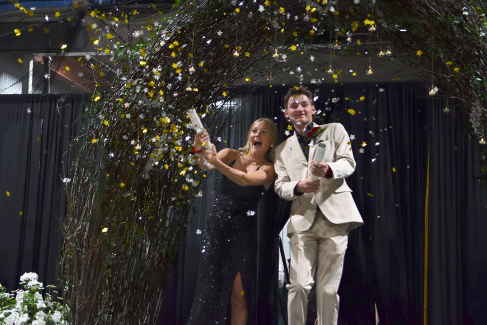 Rylyn Hayes with grad Carsen Anderson armed with confetti launchers during the grad parade.