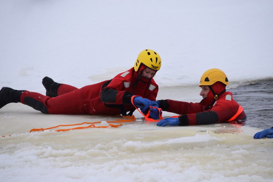 Barrhead firefighter Falon Arnott practices using a web-type strapping to rescue her colleague Jesse Whitney during a cold water exercise at the Barrhead reservoir.
Barry Kerton/BL