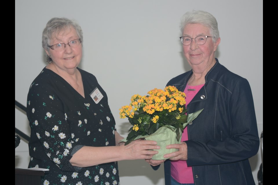 On March 25, Barrhead Women’s Conference committee member Marilyn Flock, at left, presents a ‘thank you’ gift of flowers to Maureen Greig, who has been on the committee since the first Farm Women’s Day was held back in 1984, but now retiring.