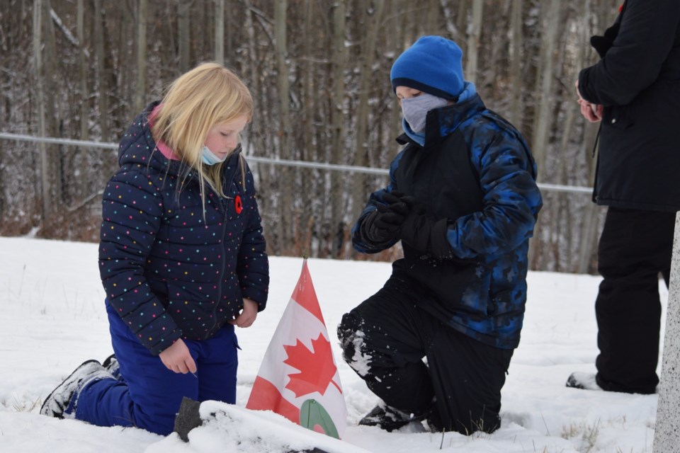 Samantha Pederson and Jaison Peloquin prepare a grave for their poppy wreath.
Barry Kerton/BL