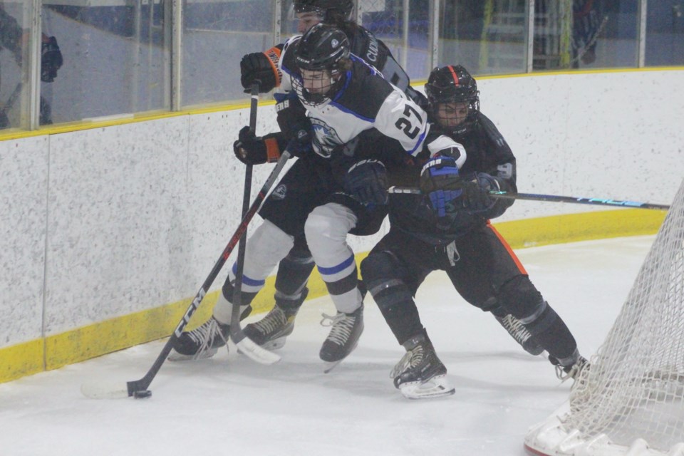 Barrhead Bomber Garrick Denchuck fights through two Hinton players for a loose puck in the third period of a Feb. 2 home game.