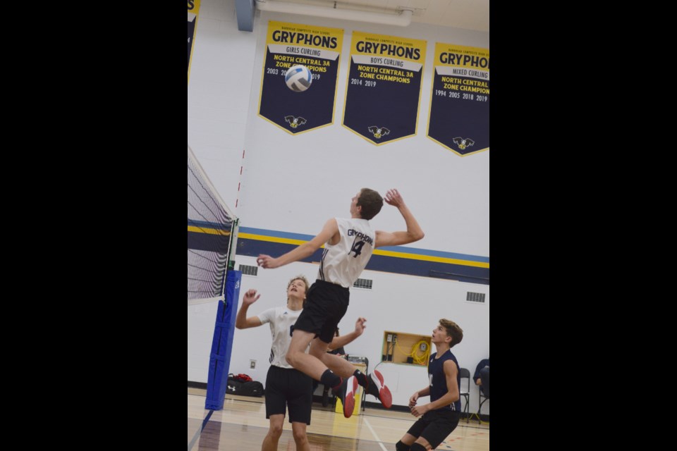 Gerrit Koekkoek goes up for a spike in the quarter-final against Athabasca with Nate Callihoo (left) and Kaden Callihoo looking on.