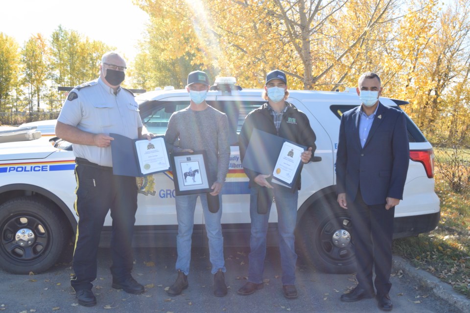 During a short Oct. 1 ceremony, RCMP Eastern District Supt. Shane Ramteemal and Barrhead Detachment Commander Bob Dodds award Nolan Tuininga and Quinn Meunier with District Commander's Certificate of Appreciation. Pictured from left are Sgt. Bob Dodds, Nolan Tuininga, Quinn Meunier and RCMP Eastern District Supt. Shane Ramteemal.