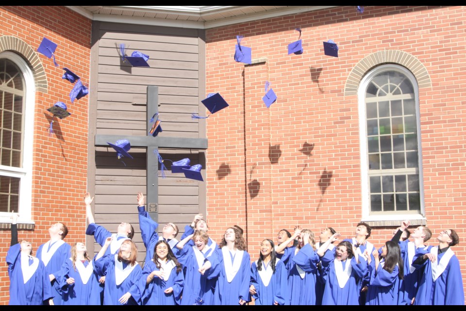 The 2024 graduates of St. Mary School in Westlock gather together outside of St. Mary Catholic Church to perform the traditional hat toss. This took place following a brief ceremony inside the church.