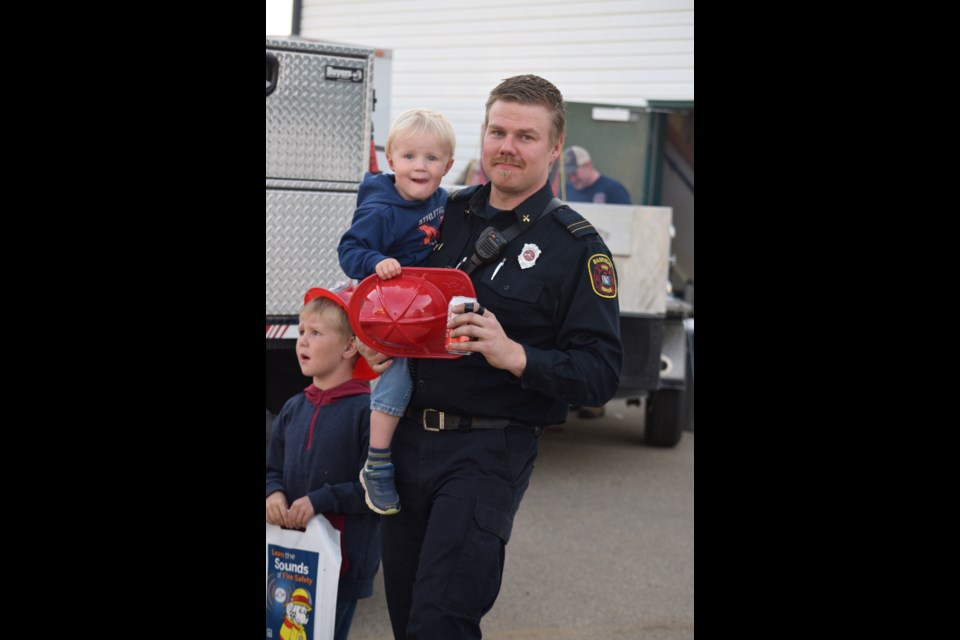 BRFS firefighter Hielke Vandermeulen with his boys, Owen (left) and Jaxon (in Vandermeulen's arms) watching the rappelling demonstration from below. 