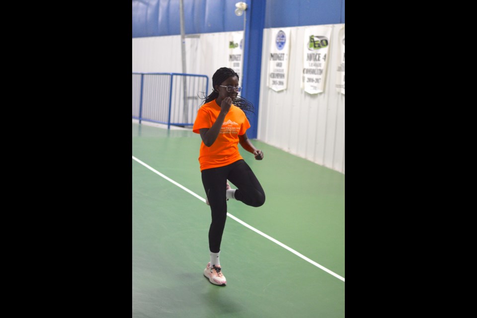 Hoza Sano warming up with some high knee lifts during a BES indoor running track team practice on Feb. 15 at the Barrhead Agrena.

