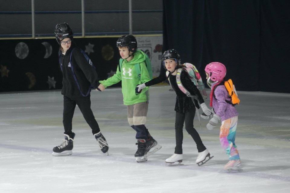 A group of backpack-wearing skaters — Daisy Blaikie, Maddy Beeson, Alexander Sehleier and Rhett Blaikie — skate down the ice to the tune “School’s Out For Summer.” 