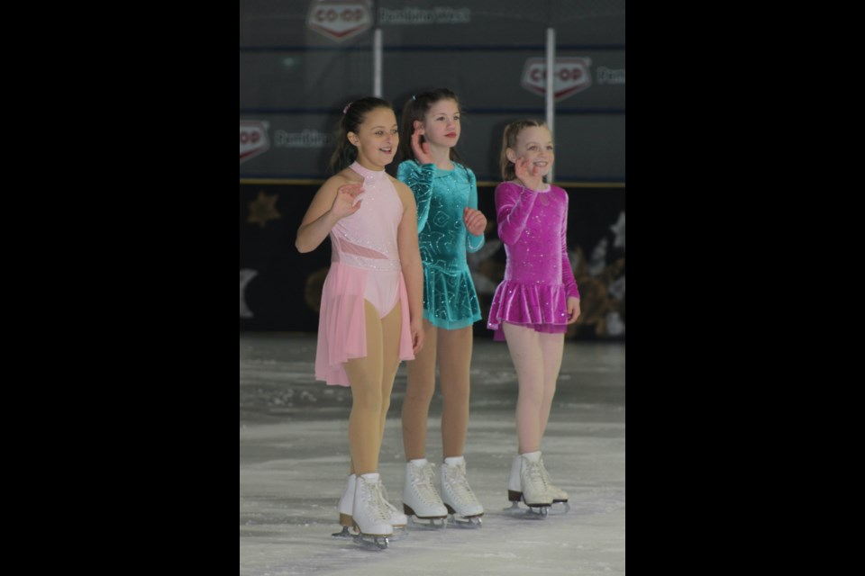 Seraya Hiemsta, Layla Blaikie and Evelynn Bartholow wave to the audience during the finale, when all the skaters came together on the ice.