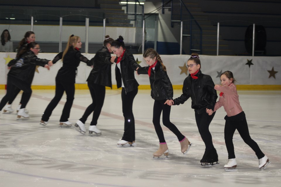 The STAR Skaters spin around the ice in a line while skating to the song "We Go Together" from Grease.