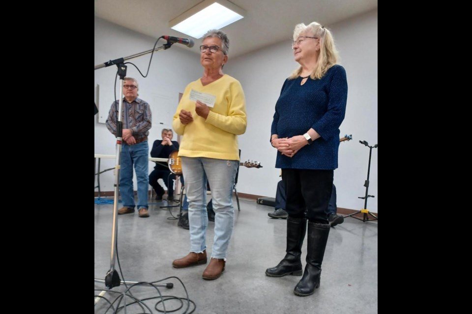 Violet Schriever from the Cancer Treatment Centre, left, accepts a cheque for $700 from Victoria Thomson of the Westlock Jamboree, right, during their monthly jamboree on Jan. 21 at the Memorial Hall. Submitted photo 
