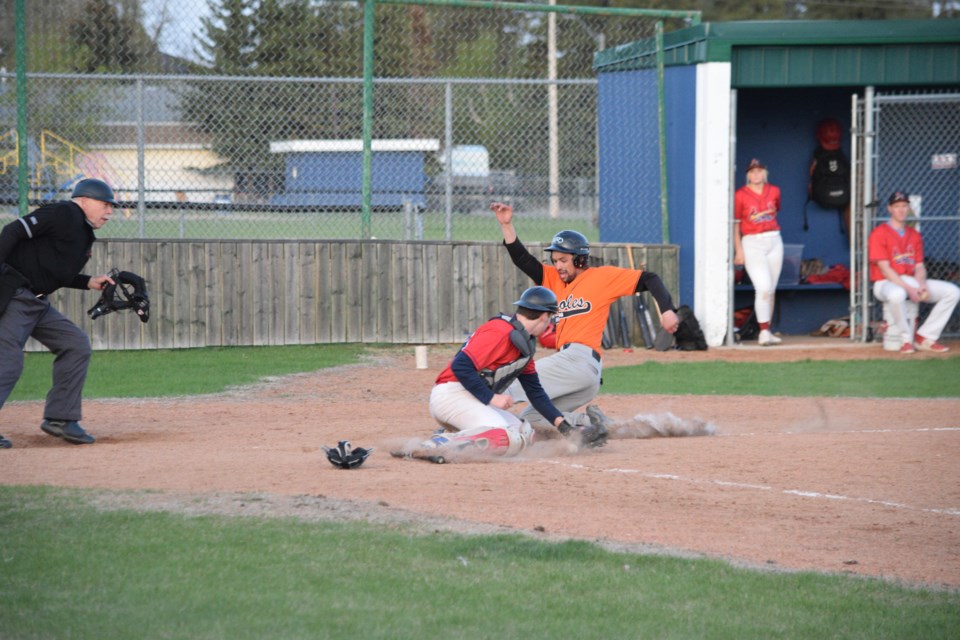 Barrhead starting catcher Johnny Klein beats the tag sliding at home plate, scoring one of the Orioles' four runs in the fifth inning.